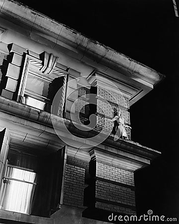 Woman standing on the top of a building on a ledge Stock Photo