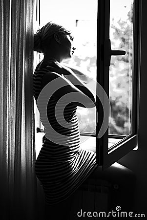 Woman standing at the window Stock Photo