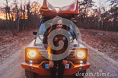 Woman stands front off 4x4 terrain vehicle. Stock Photo