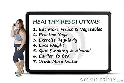 Woman stands with healthy resolutions on board Stock Photo