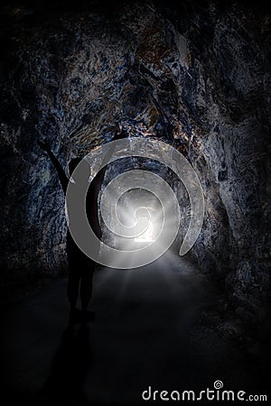 Woman Stands Inside Tunnel With Blinding Light Stock Photo