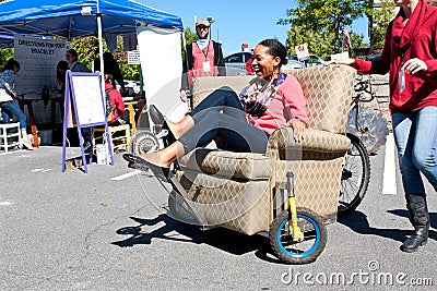 Woman Steers Oddball Furniture Piece On Wheels At Unique Fair Editorial Stock Photo