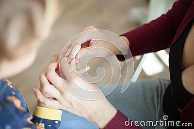 Woman sticks a band-aid son cut finger Stock Photo