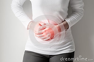 Woman stomachache on gray wall background. Stock Photo