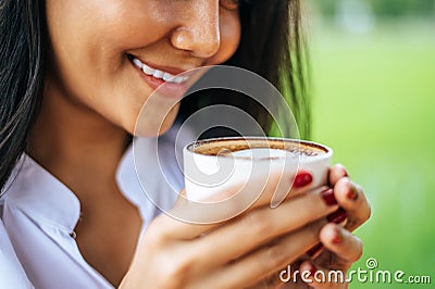 That woman stood happily drinking coffee on the meadow Stock Photo