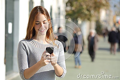 Woman in the street browsing a smart phone Stock Photo