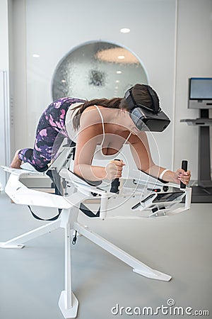 Woman strengthening her muscles with an innovative VR training Stock Photo