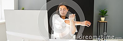 Woman Stretches At Office Desk Stock Photo