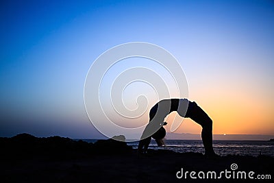 Woman stretches yoga sunset silhouette Stock Photo