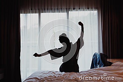 Woman stretching on bed after wake up, back view Stock Photo