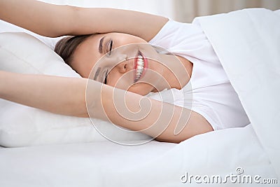 Woman stretching in bed after wake up, entering a day happy and relaxed after good night sleep. Sweet dreams, good Stock Photo