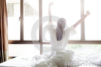 Woman stretching in bed after wake up. Stock Photo