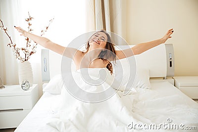 Woman stretching hands on the bed