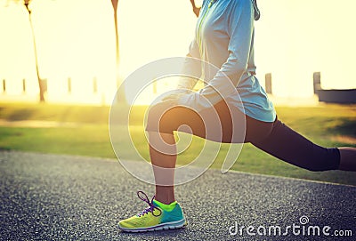 woman stretching legs before run at tropical park Stock Photo