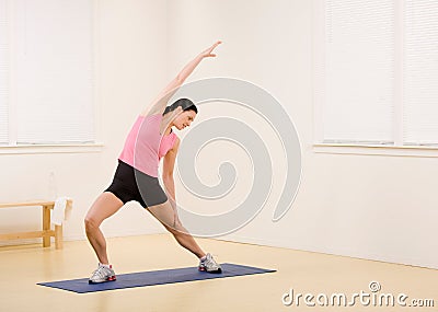 Woman stretching on yoga mat Stock Photo