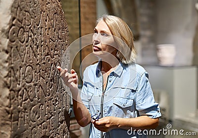 Woman studying ancient writing hieroglyphs at museum of arts Editorial Stock Photo