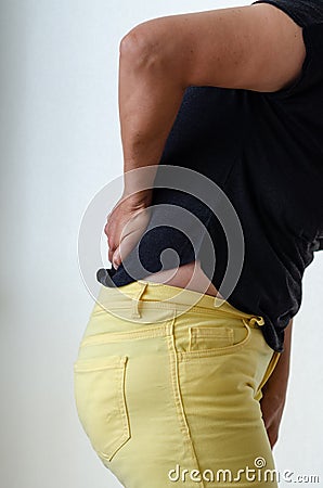 Woman suffering from backache at front of white background Stock Photo
