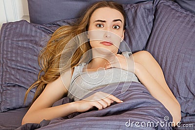 Woman suffering from insomnia or indisposition in bed at home and looking at camera Stock Photo