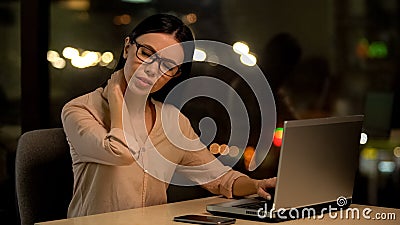 Woman suffering neck pain after working on laptop for long period, muscle strain Stock Photo