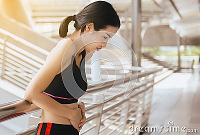 Woman suffering from pain and colic is a frequent problem after sport exercise running jogging and workout Stock Photo