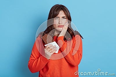 Woman suffering from toothache after eating chocolate frowning her face covering cheek with palm female with dark hair wearing Stock Photo