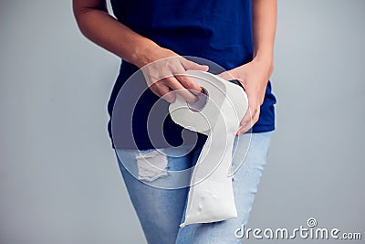 Woman suffers from diarrhea holds toilet paper roll. Stomach ups Stock Photo