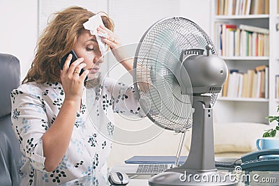 Woman suffers from heat in the office or at home Stock Photo