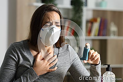 Woman suffocating due covid-19 holds inhaler at night Stock Photo