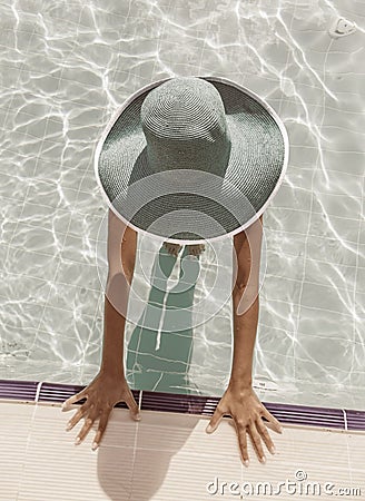 Woman in sun hat in the swimming pool. Top view. Stock Photo