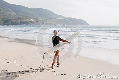 Woman with surfing board on the beach Stock Photo