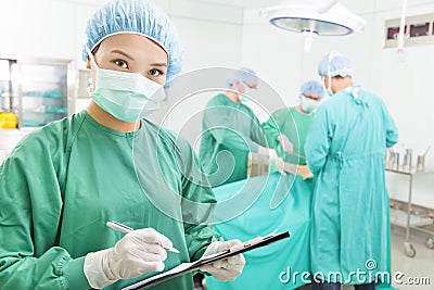 Woman Surgeons writing medical record Stock Photo