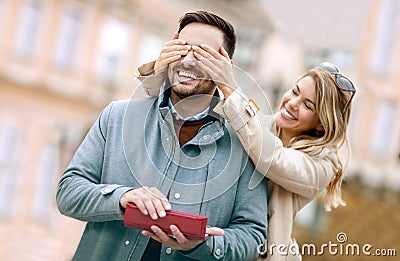 Woman surprising his boyfriend with a gift. Stock Photo