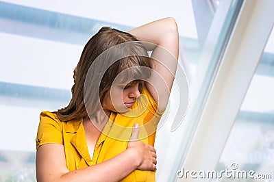 Woman with sweating under armpit in yellow dress Stock Photo