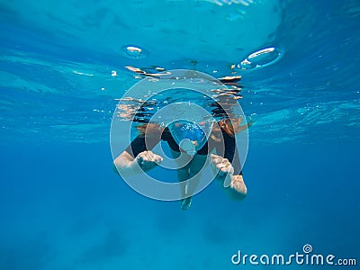 Woman swimming in blue water. Beautiful woman under water before dive to coral reef Stock Photo