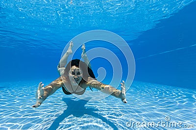 Woman swimming underwater in a pool Stock Photo