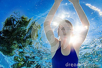 Woman swims underwater in swimming pool, healthy active girl dives and has fun under water, fitness and sport on vacation Stock Photo