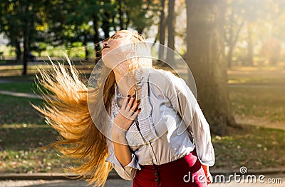 Woman swinging hair in the park, healthy hair concept Stock Photo