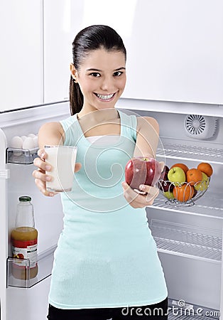 Woman take red apple and milk from fridge Stock Photo