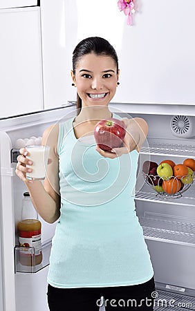 Woman take red apple and milk from fridge Stock Photo