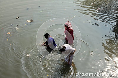Woman takes holy dip in the Adi Ganga river near Kalighat temple Editorial Stock Photo