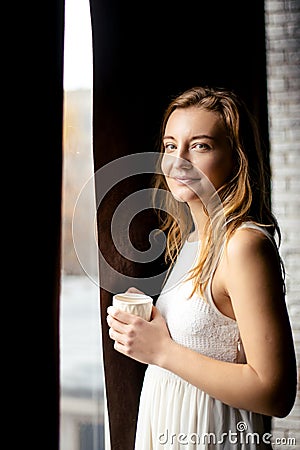 A woman takes a moment to savor the simple pleasure of a cup of coffee, the perfect way to start the day Stock Photo