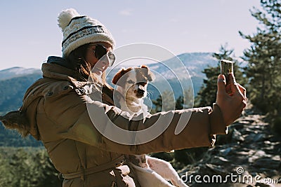 Woman takes a picture with her dog on the mountain Stock Photo