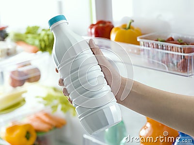 Woman taking a bottle of milk from the fridge Stock Photo