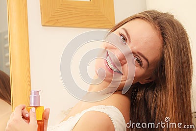 Woman taking care of her long hair applying cosmetic oil Stock Photo