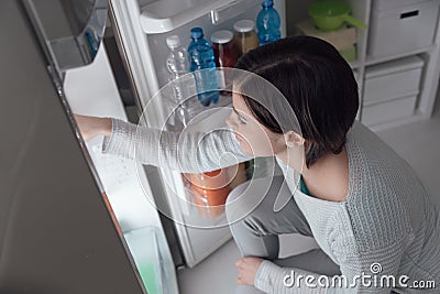 Woman taking food out of the fridge Stock Photo