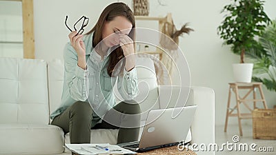 Woman taking off glasses tired of laptop work, problem after long laptop use, eyes fatigue concept Stock Photo