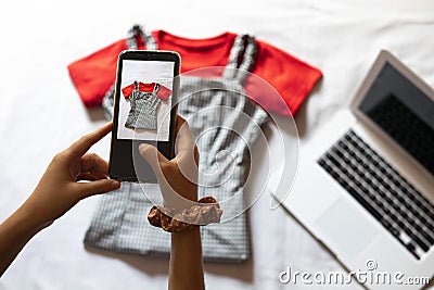 Woman taking a photo of an article of clothing to sell online. Concept of selling clothes online. Stock Photo