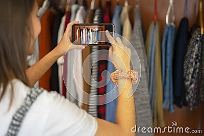 Woman taking a photo with her mobile of the wardrobe. Photograph the closet. Stock Photo