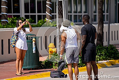 Woman taking photos of spring break tourists in Miami Beach Editorial Stock Photo