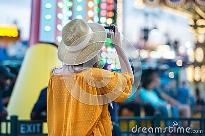 Woman taking picture at amusement park during her travel at summer vacation Stock Photo